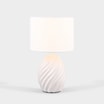 Lampa stołowa biała zaświecona widoczna od przodu.