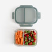 Otwarty lunchbox szklany dripstop widziany od góry, z warzywami umieszczonymi w dwóch oddzielnych komorach i pokrywką odłożoną.