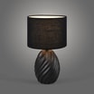 Lampa stołowa czarna zaświecona na szarym tle.
