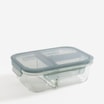 Szklany lunchbox dripstop z trzema przegrodami i zamkniętą pokrywką widoczny od przodu pod lekkim kątem na jasnym tle.