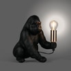 Lampa stołowa czarna kong widoczna od frontu zaświecona.