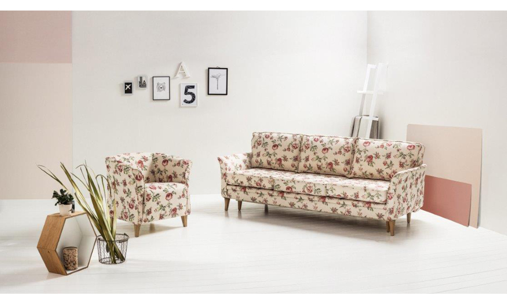 Sofa i fotel w kwiatowy wzór w jasnej aranżacji salonu inspirowanej stylem prowansalskim