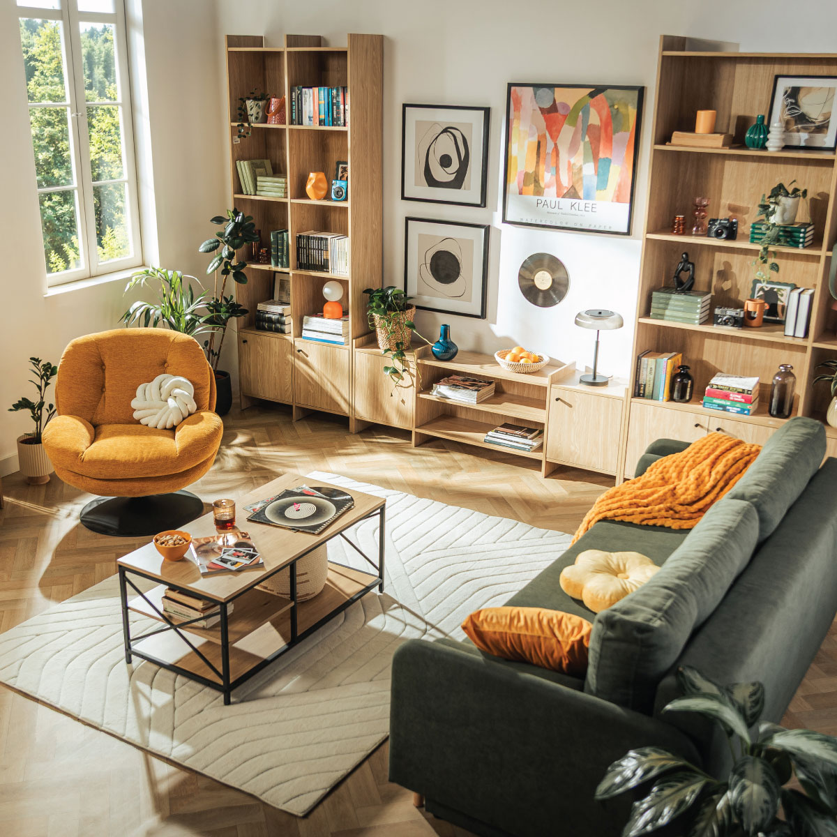 Widok z góry na salon w stylu Retro z kolekcją Magnus, z zielona sofą tampa, stolikami kawowymi, dywanem i dekoracjami.