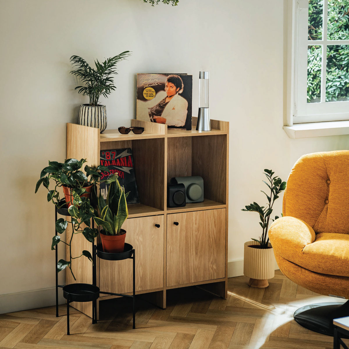 Komoda Magnus w kolorze dębu z dekoracjami i ceramiką w salonie inspirowanym stylem Retro.