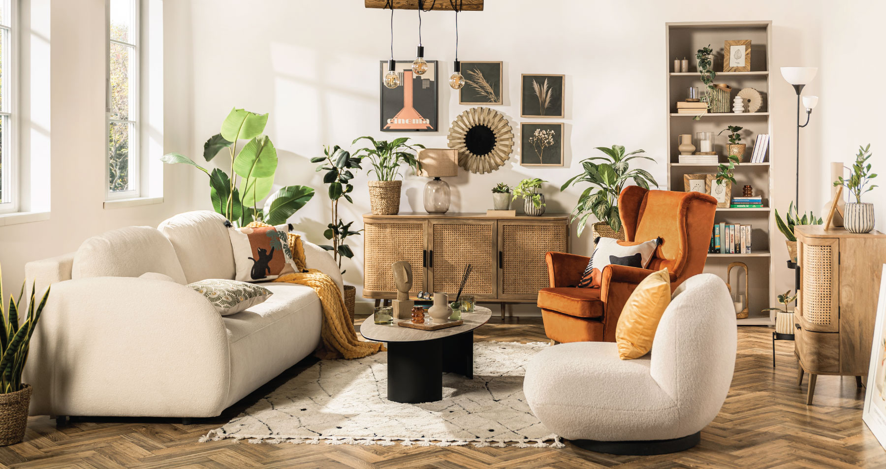 Salon w stylu etno z beżową sofą Roma, meblami Fabla, ceramiczną ławą Remdovia, pomarańczowym fotelem Maivilli, kremowym fotelem Vizzo oraz naturalnymi dekoracjami inspirowanymi podróżami.