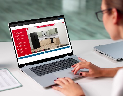 Osoba korzysta z laptopa z otwartym planerem mebli kuchennych na stronie agatameble.pl, umożliwiającym projektowanie i personalizację zabudowy kuchennej online.