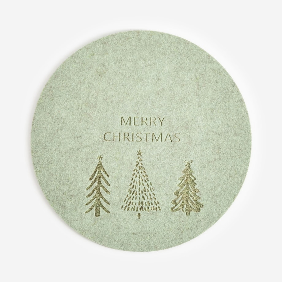 Okrągła zielona podkładka świąteczna z motywem trzech choinek i napisem merry christmas widoczna w całości na jasnym tle.