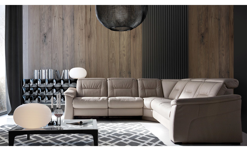 Narożnik z funkcją relaksu w nowoczesnym salonie z drewnianą ścianą i designerskimi dodatkami