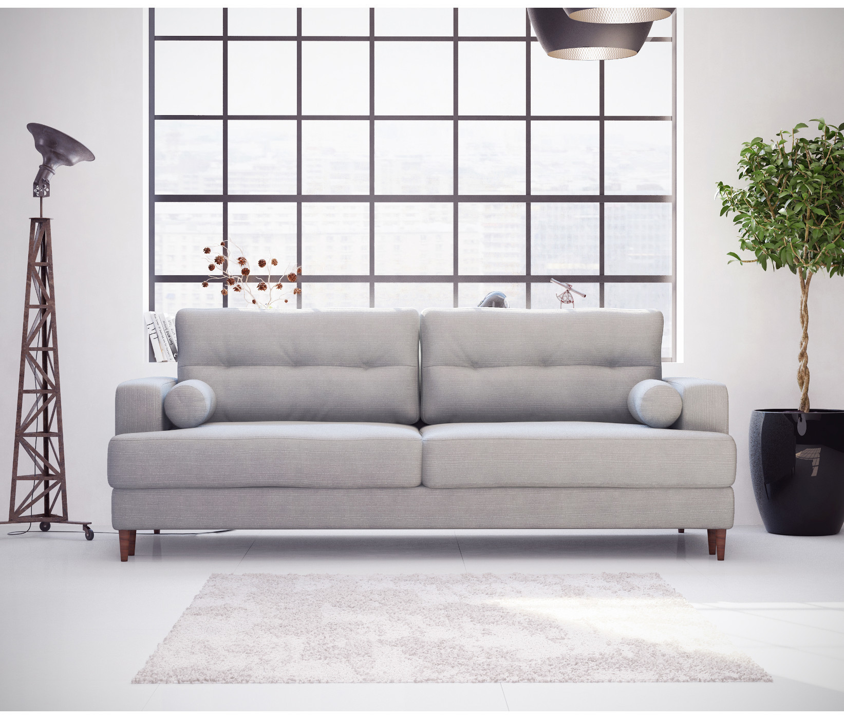 Szara sofa z poduszkami w formie walca przy loftowym oknie.