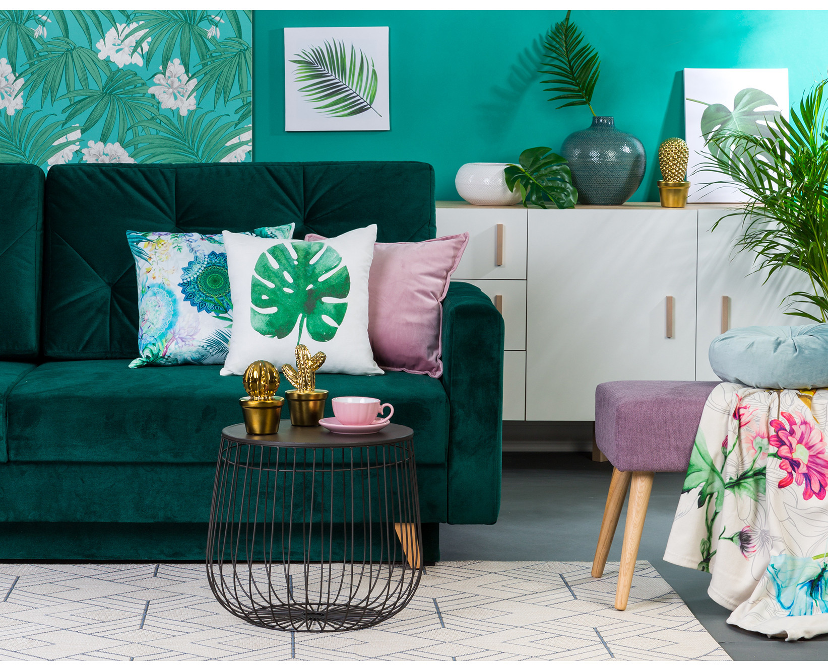 Zielona sofa welurowa przy tropikalnej tapecie