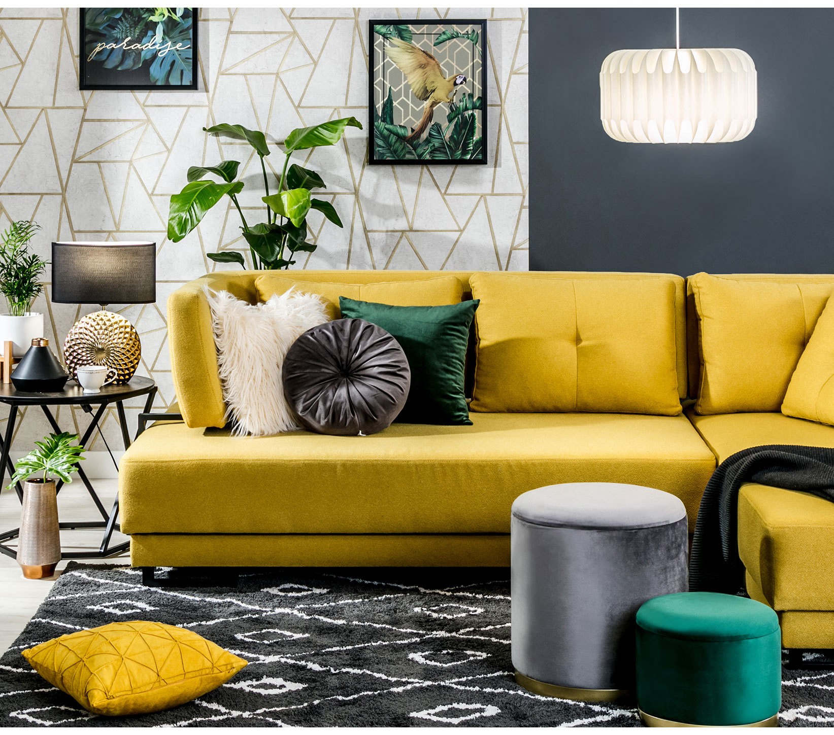 Żółta sofa z poduszkami przy geometrycznej tapecie