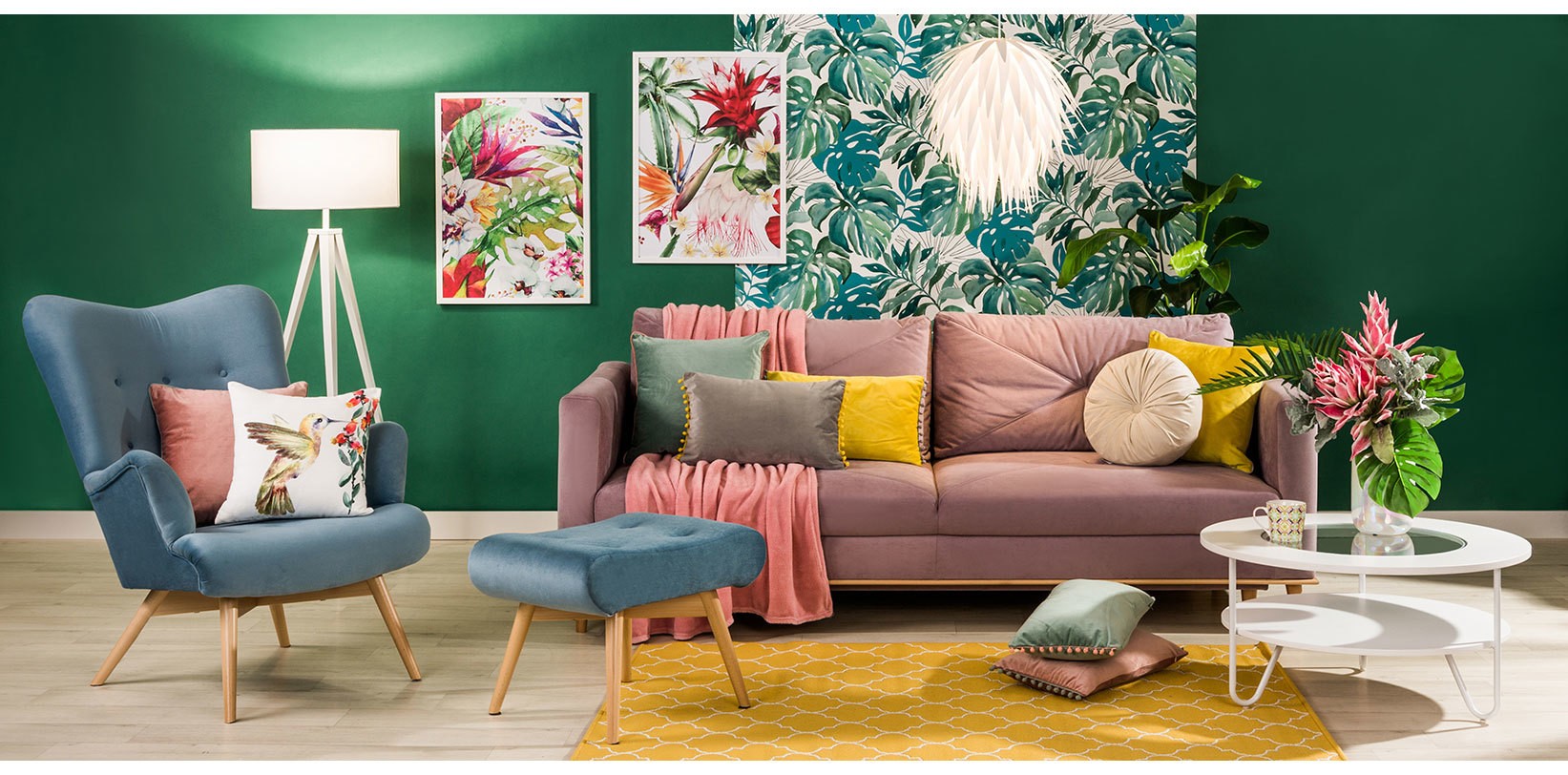 Kolorowy salon z różową sofą, niebieskim fotelem i tropikalną tapetą w stylu urban jungle