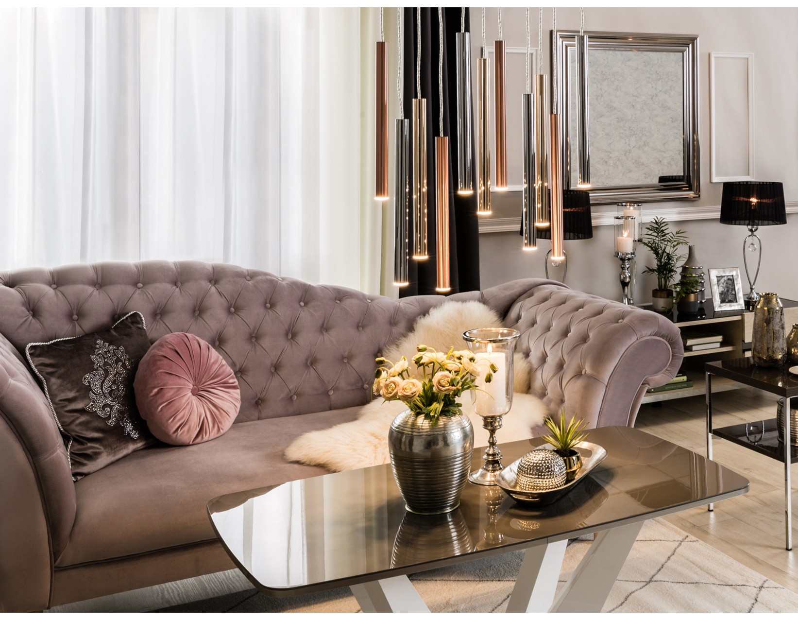 Pudrowa pikowana sofa w stylu glamour z lustrem w eleganckim salonie. 