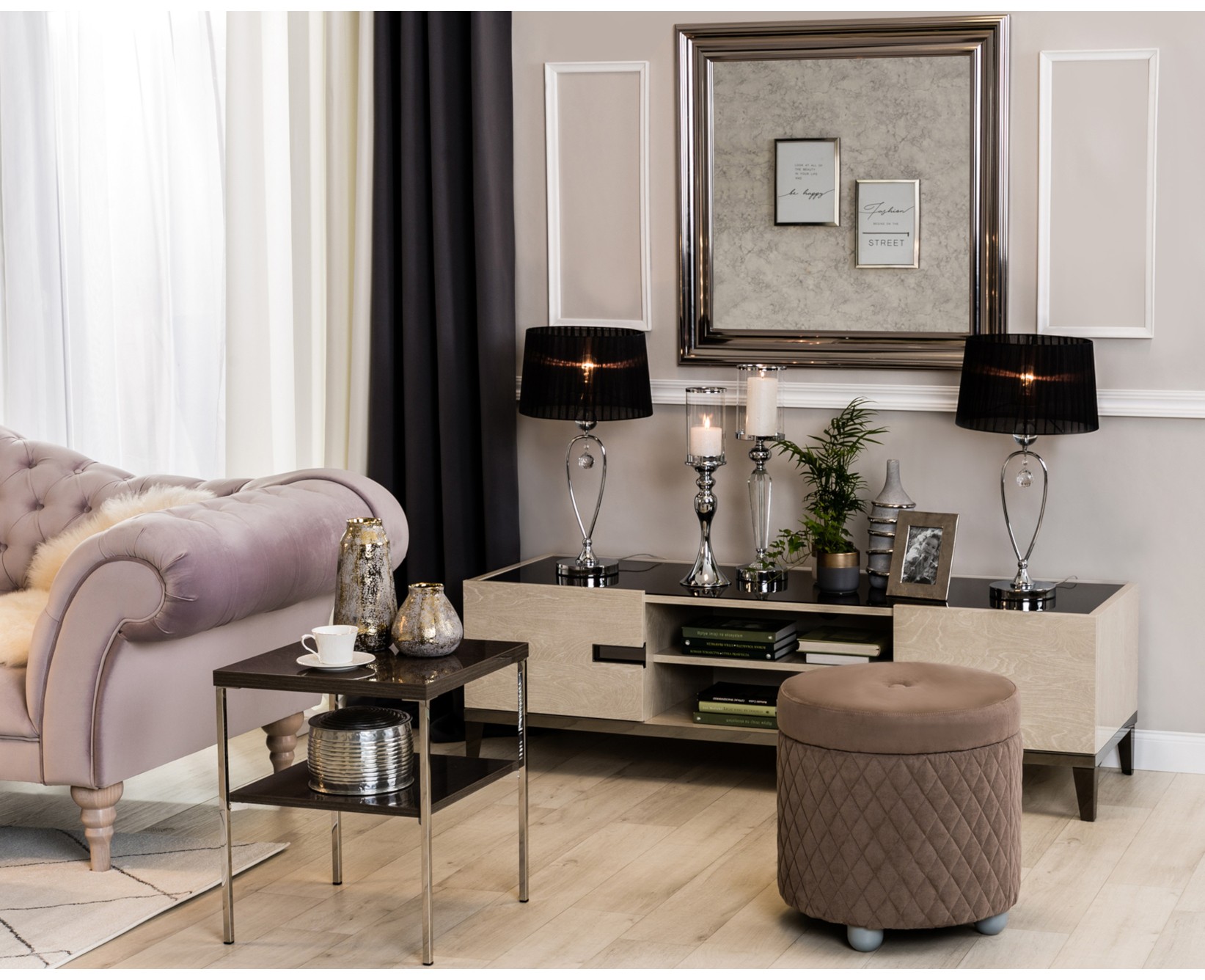 Szafka RTV w stylu glamour z czarnymi lampami, różową sofą chesterfield i eleganckimi dodatkami.