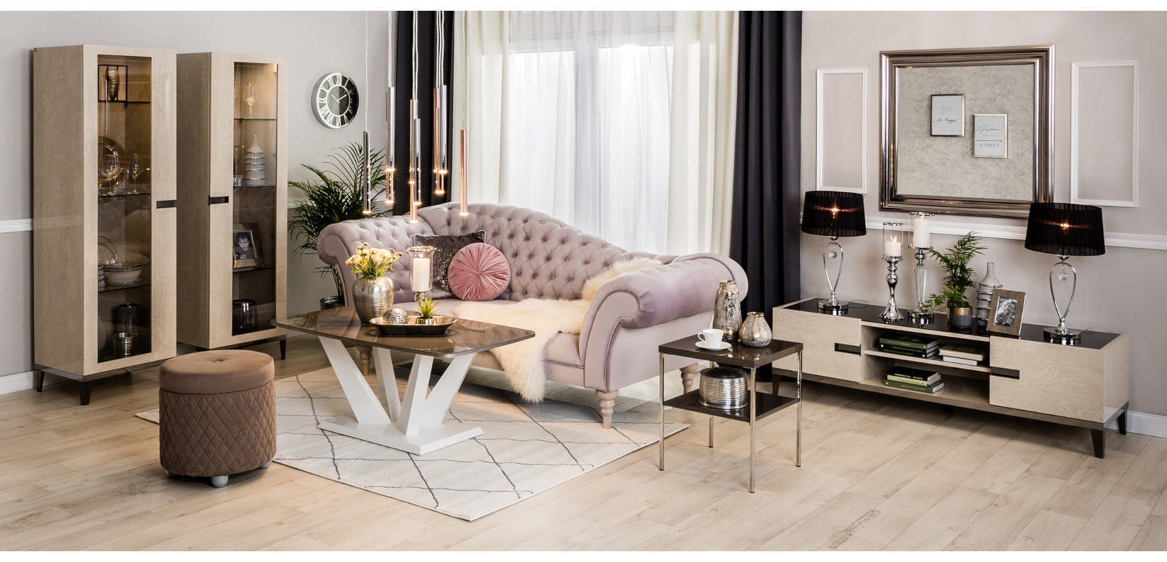 Salon glamour z różową sofą chesterfield, witrynami, szafką RTV i eleganckimi dodatkami.