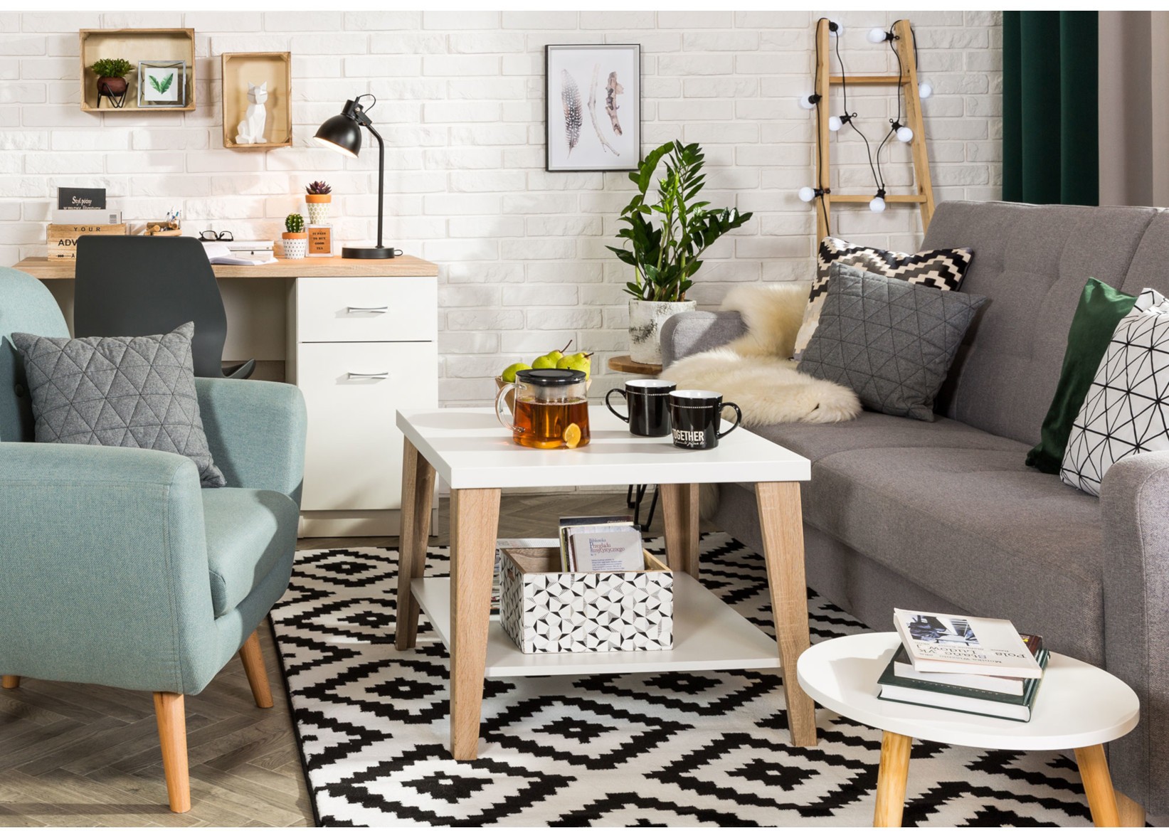 Szara sofa, błękitny fotel i biały stolik kawowy w nowoczesnym salonie w stylu skandynawskim.