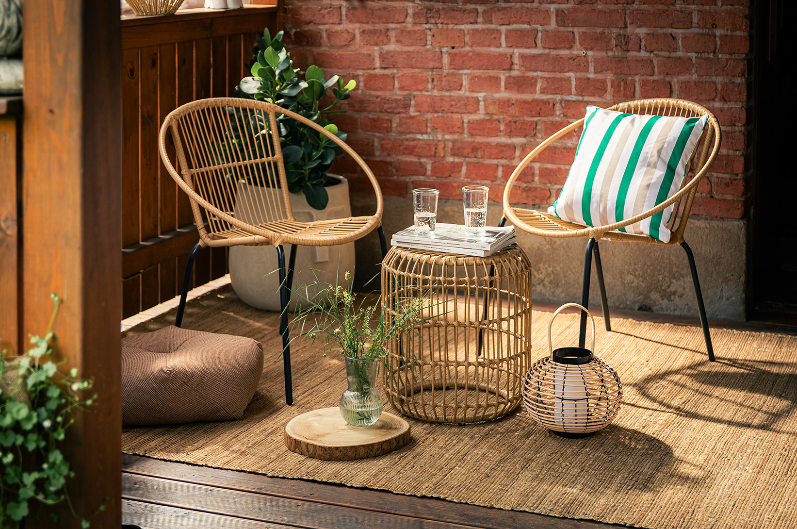 Przytulny balkon z rattanowymi fotelami, stolikiem kawowym, lampionem oraz naturalnymi dodatkami w stylu boho.