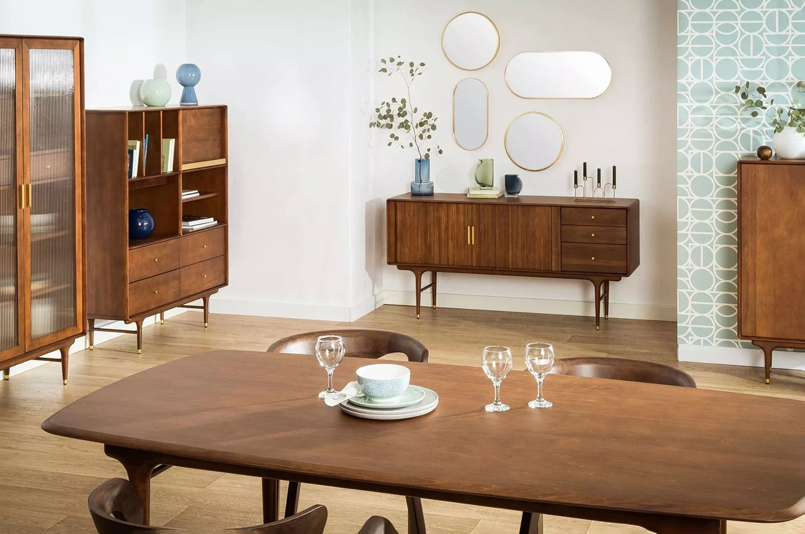 Nowoczesna jadalnia z drewnianym stołem, designerską komodą oraz witryną w stylu mid-century.