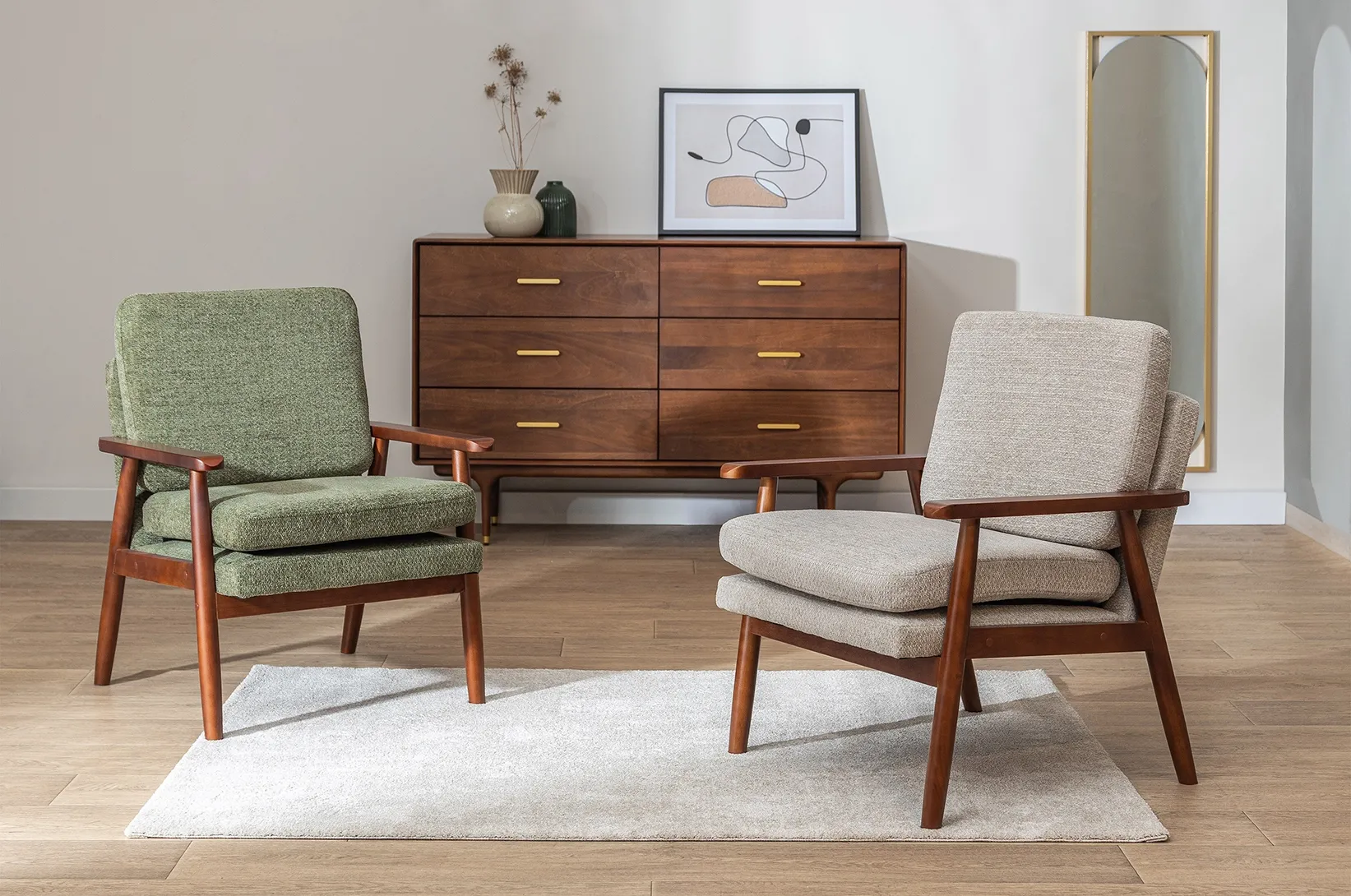Dwa tapicerowane fotele w stylu retro oraz drewniana komoda z szufladami w eleganckiej aranżacji salonu inspirowanej designem mid-century modern.