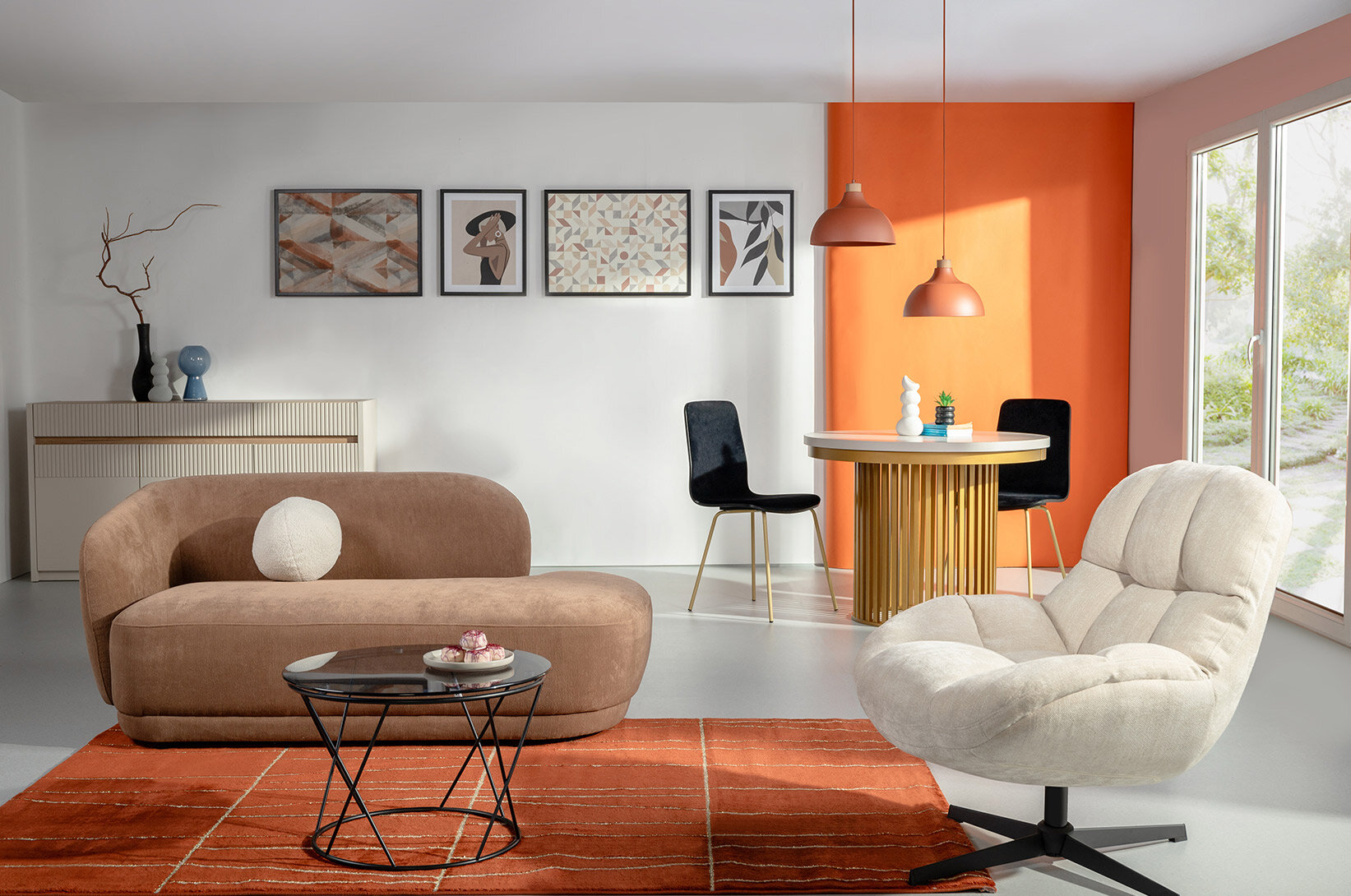 Nowoczesny salon z beżową sofą, jasnym fotelem, okrągłym stolikiem kawowym oraz jadalnią z dekoracyjnymi lampami wiszącymi na tle pomarańczowej ściany.