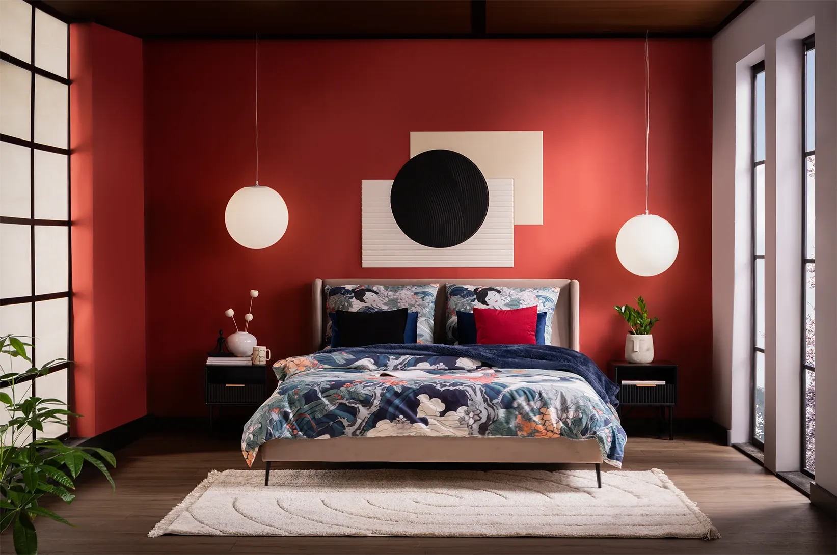 Nowoczesna sypialnia z tapicerowanym łóżkiem, wzorzystą pościelą i czerwoną ścianą, elegancka aranżacja wnętrza z designerskimi lampami wiszącymi i dekoracyjnymi dodatkami.