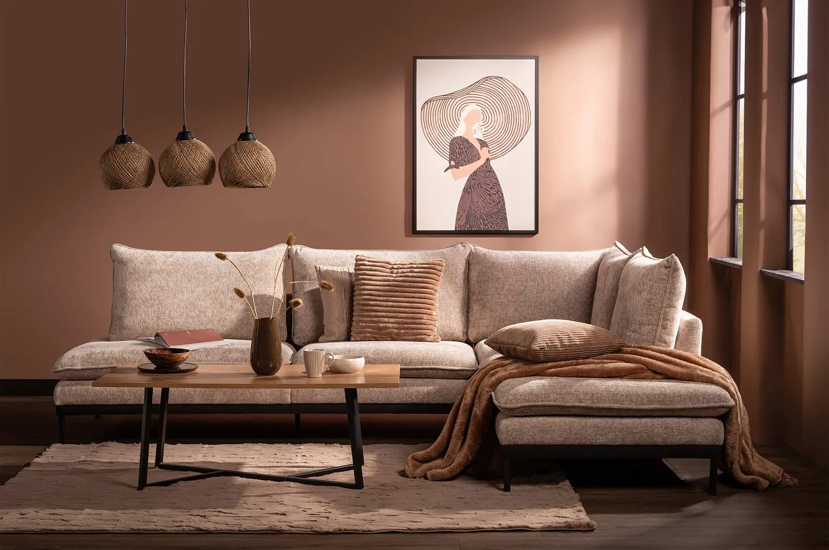 Brązowy salon z narożnikiem w kolorze taupe, drewnianym stolikiem kawowym oraz dekoracyjnymi poduszkami, przytulna aranżacja wnętrza w odcieniach brązu i beżu.